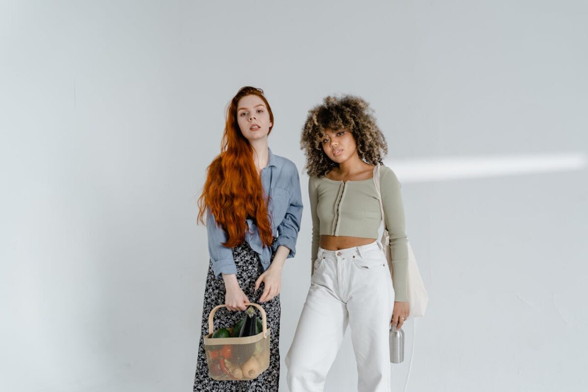 Diverse women posing with eco-friendly items and fashion on a white background.